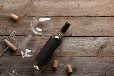 Şarap şişeleri, bardaklar, mantar ve tirbuşon tahta masa, düz yatak. Metin için boşluk