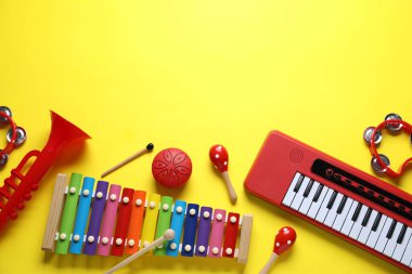 Düz kompozisyon ve sarı arka planda farklı müzik aletleri. Metin için boşluk