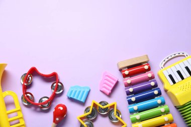 Menekşe arka planda farklı oyuncak müzik aletleri, düz yatış. Metin için boşluk