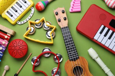 Yeşil arka planda farklı oyuncak müzik aletleri, düz yatış