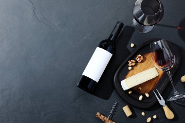 Lezzetli şarap, peynir ve fındıklı siyah arka plan, düz yatak. Metin için boşluk