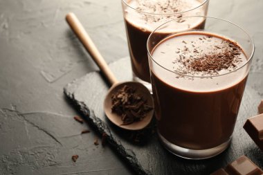 Lezzetli çikolatalı süt, talaş ve siyah masa parçaları, yakın plan. Metin için boşluk