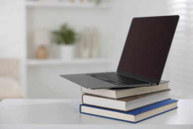 Beyaz masa içerisindeki farklı kitap ve dizüstü bilgisayar. Metin için boşluk