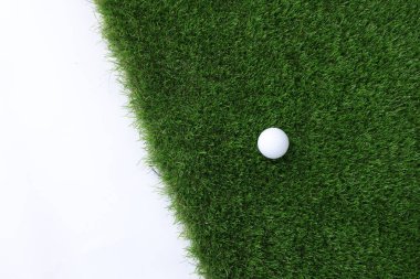 Beyaz arka planda golf topu ve yeşil çimenler, üst manzara. Metin için boşluk