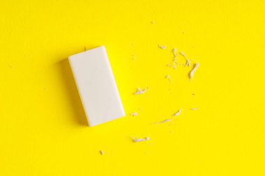 Sarı arka planda bir silgi ve kırıntılar, üst görünüm