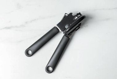One can opener on white marble table, top view
