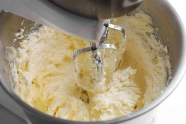 Beyaz masada çırpılmış kremayla karıştırma, yakın plan.