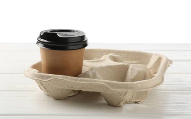 Kağıt kahve fincanı beyaz ahşap masanın üzerinde karton tutacakta, yakın plan.