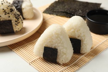 Pirinç topları (onigiri) ışık masasında, yakın plan. Geleneksel Japon yemeği
