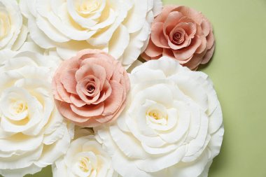 Açık yeşil zemin üzerinde güzel kağıt çiçekler, düz uzanmış