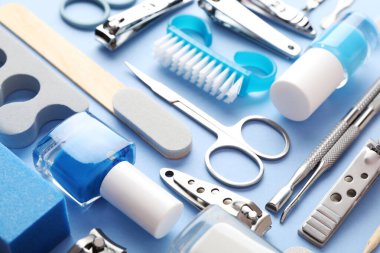 Açık mavi arkaplanda farklı manikür araçları seti, yakın plan