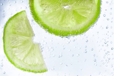 Beyaz arka planda limon dilimli soda, yakın plan.