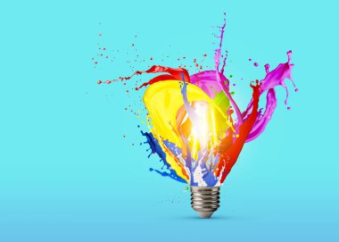 Fikir konsepti. Açık mavi arka planda parlayan ampulden parlayan parlak boya damlaları