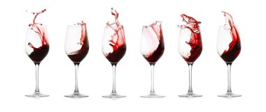 Kırmızı şarap beyaz arka planda bardaklara sıçrıyor.