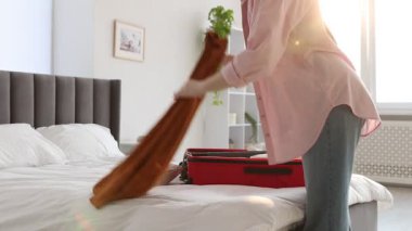 Kadın bavulu içine koymadan önce etek paketliyor.