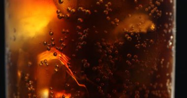 Siyah arka planda buzlu kolayı ve buzları tazeliyorum. Yakın plan. Kamera yukarı hareket ediyor