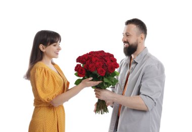 Adam beyaz arka planda sevgilisine kırmızı gül buketi sunuyor.