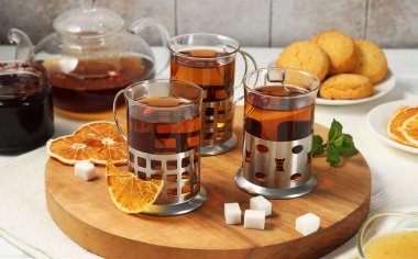 Beyaz ahşap masada servis edilen metal tutacaklı çay bardakları