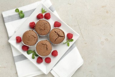 Ahududu ve nane aromalı lezzetli çörekler gri desenli masa, üst manzara. Metin için boşluk