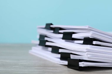 Tahta masadaki kağıtların olduğu ataçlar, yakın plan.