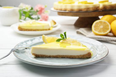 Beyaz ahşap masada servis edilen limonlu nefis peynirli kek, yakın plan.