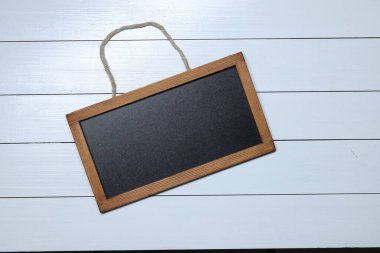 Beyaz ahşap zemin üzerinde boş küçük karatahta, üst görünüm