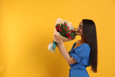 Sarı arka planda kırmızı lale çiçekli mutlu kadın, mesaj için yer var. 8 Mart kutlamaları