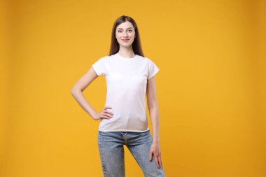 Turuncu arka planda beyaz tişört giyen bir kadın. Tasarım için model