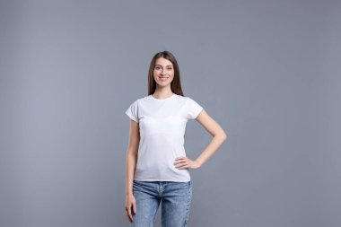 Açık gri arka planda beyaz tişört giyen bir kadın. Tasarım için model
