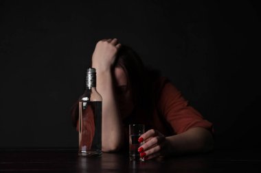 Alkol bağımlılığı. Masasında votka olan sefil bir kadın.
