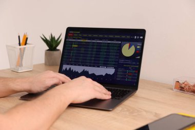 Borsa. Bilgisayardaki finansal piyasayı analiz eden adam, kapalı alanda, yakın planda.