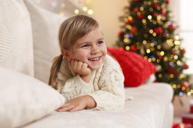 Evdeki kanepede yatan küçük kız. Noel kutlaması