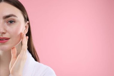 Pembe arka planda sağlıklı cildi olan bir kadın. Metin için boşluk