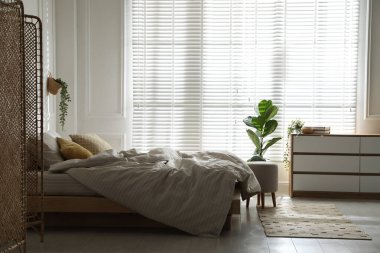 Şık bir odada yumuşak çarşafları olan rahat bir yatak. İç tasarım