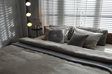 Şık bir odada yatağın yanında lamba. İç tasarım