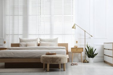 Şık bir odada yumuşak çarşafları olan rahat bir yatak. İç tasarım