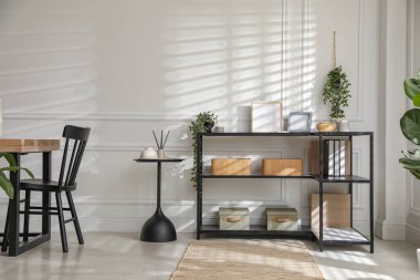 Beyaz duvarın yanında farklı dekorları ve sandalyeleri olan konsol masası. İç tasarım