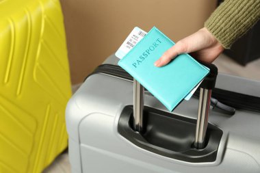 Pasaportu, bileti ve bavulu olan bir kadın, yakın plan.