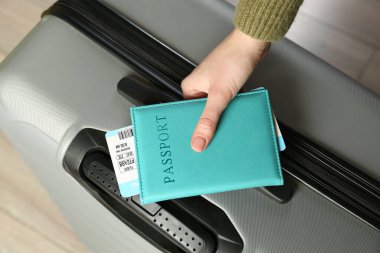 Pasaportu, bileti ve bavulu olan kadın, yakın plan.