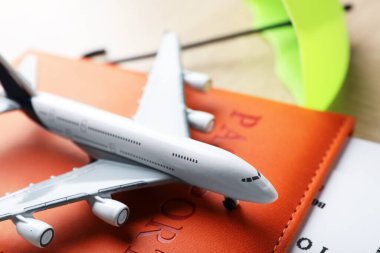 Seyahat sigortası. Uçak modeli, pasaport, küçük şemsiye ve biletler ahşap masada, yakın plan.