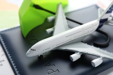 Seyahat sigortası. Uçak modeli, pasaport, bilet ve dünya haritasında küçük şemsiye, yakın plan