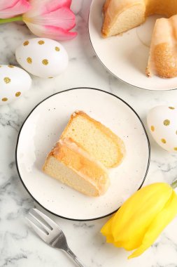 Lezzetli kek parçaları, Paskalya yumurtaları ve laleler açık mermer masa üzerinde, düz yatıyordu.