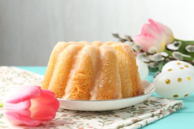 Lezzetli kek, Paskalya yumurtası, söğüt dalları ve masada laleler.