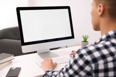 Ofisteki beyaz masada bilgisayarda çalışan bir adam, yakın plan. Tasarım için model