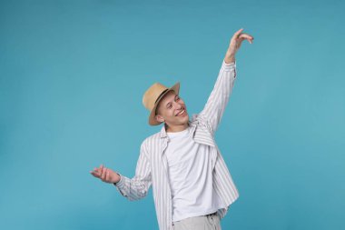 Açık mavi arka planda dans eden mutlu adam