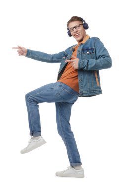Kulaklıklı mutlu adam beyaz arka planda dans ediyor.