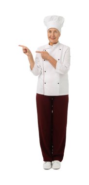 Profesyonel pasta şefi beyaz arka planda bir şeye işaret ediyor.