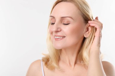 Beyaz arka planda gülümseyen orta yaşlı kadın. Metin için boşluk