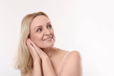 Beyaz arka planda gülümseyen orta yaşlı kadın. Metin için boşluk