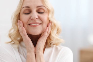 Geçmişi bulanık gülümseyen orta yaşlı bir kadın. Metin için boşluk